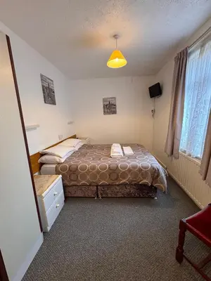 a bedroom with a bed and a yellow light at OYO Delton Hotel Blackpool Pleasure Beach in Blackpool