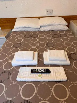 a bed with two towels and a remote control on it at OYO Delton Hotel Blackpool Pleasure Beach in Blackpool
