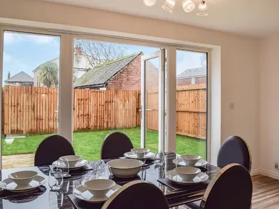 a dining room with a table and chairs and a large window at The Goldsmith in Blackpool