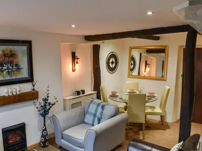 a living room with a couch and a table and chairs at Byways in Cartmel