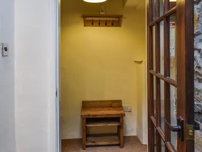 a small wooden table in a room with a yellow wall at Byways in Cartmel