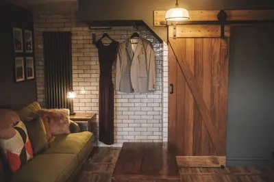 a room with a couch and a wooden door at The Coach House Heysham in Heysham