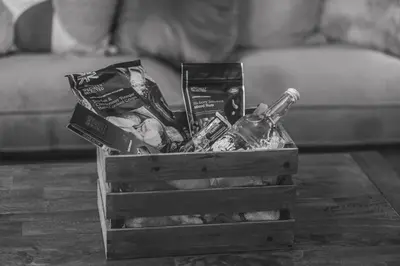a wooden crate filled with food and drinks on a table at The Coach House Heysham in Heysham