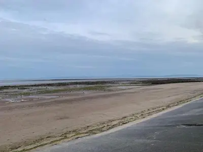 an empty beach with the ocean in the background at The Coach House Heysham in Heysham