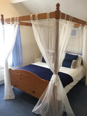 a bedroom with a canopy bed with curtains at Marlow Lodge in Blackpool