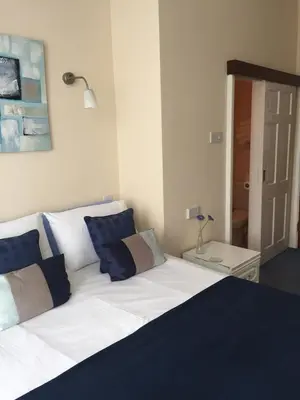 a bed with blue and white pillows in a room at Marlow Lodge in Blackpool