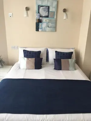 a large bed with blue and white pillows on it at Marlow Lodge in Blackpool