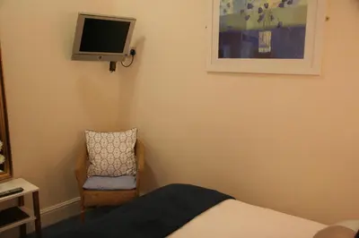 a bedroom with a bed and a tv and a chair at Marlow Lodge in Blackpool