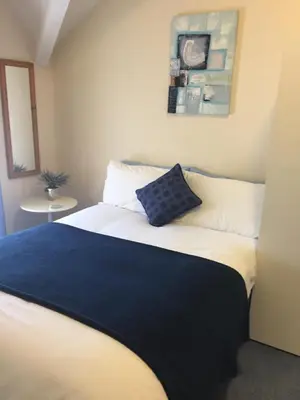 a bedroom with a bed with a blue pillow on it at Marlow Lodge in Blackpool