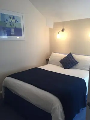 a hotel room with a bed with a blue blanket at Marlow Lodge in Blackpool
