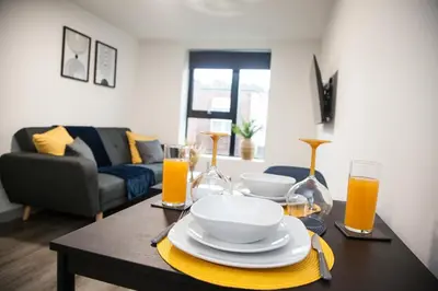 a living room with a table with plates and glasses at Modern 1-Bedroom Liverpool Apartment, Cosy & Fast Wi-Fi in Liverpool