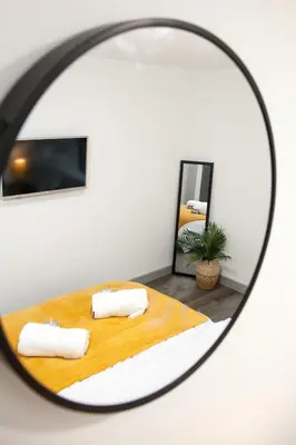 a mirror reflecting a bedroom with a bed with two pillows at Modern 1-Bedroom Liverpool Apartment, Cosy & Fast Wi-Fi in Liverpool