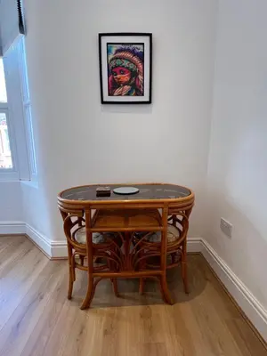 a table in a room with a picture on the wall at 2025 Award Winner Liverpool Cherry House - 4 Bedrooms in Liverpool