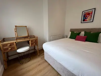 a bedroom with a bed and a dressing table with a mirror at 2025 Award Winner Liverpool Cherry House - 4 Bedrooms in Liverpool