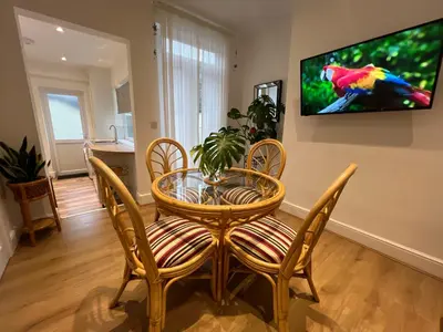 a dining room with a table and chairs and a tv at 2025 Award Winner Liverpool Cherry House - 4 Bedrooms in Liverpool