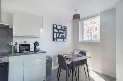 a kitchen with a table and chairs and a microwave at Modern 1 Bedroom Liverpool Apartment in Liverpool
