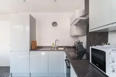 a white kitchen with a sink and a microwave at Modern 1 Bedroom Liverpool Apartment in Liverpool