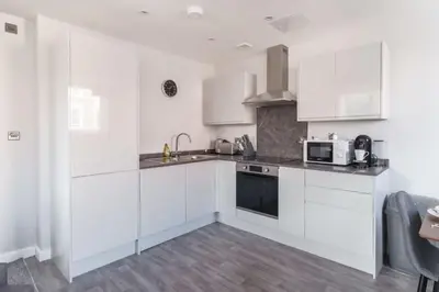 a white kitchen with white cabinets and a microwave at Modern 1 Bedroom Liverpool Apartment in Liverpool