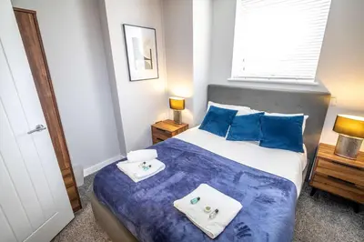 a bedroom with a bed with blue sheets and towels at Modern 1 Bedroom Liverpool Apartment in Liverpool