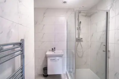 a white bathroom with a shower and a sink at Modern 1 Bedroom Liverpool Apartment in Liverpool