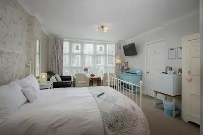a bedroom with a bed and a living room at The Wescoe Guesthouse in Blackpool