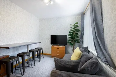 a living room with a couch and a table and a tv at SuiteSpot Serviced Apartments Blackpool in Blackpool