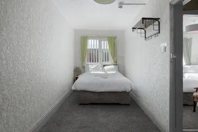 a small bedroom with a bed and a window at SuiteSpot Serviced Apartments Blackpool in Blackpool