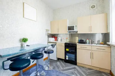 a kitchen with a counter and stools in it at SuiteSpot Serviced Apartments Blackpool in Blackpool