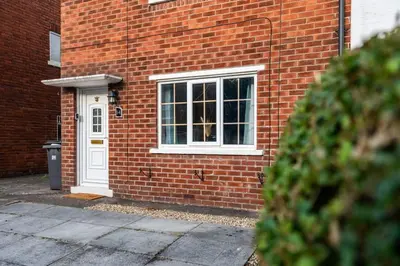 a brick building with a window and a white door at Alexandra - WiFi Parking Garden in Walton le Dale
