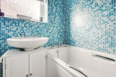 a blue tiled bathroom with a sink and a bath tub at Alexandra - WiFi Parking Garden in Walton le Dale
