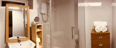 a bathroom with a shower with a toilet and a sink at The Danescourt in Blackpool