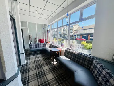 a room with couches and a table and windows at The Danescourt in Blackpool