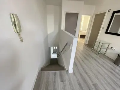 a hallway with stairs and a phone on the wall at Liverpool City Stays - Bold Street in Liverpool