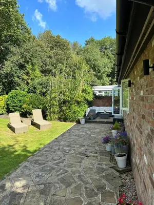 a garden with two chairs and a patio at Leafy lodge in Lytham in Brown Moss Side