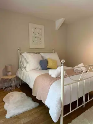 a bedroom with a bed with white sheets and pillows at Leafy lodge in Lytham in Brown Moss Side