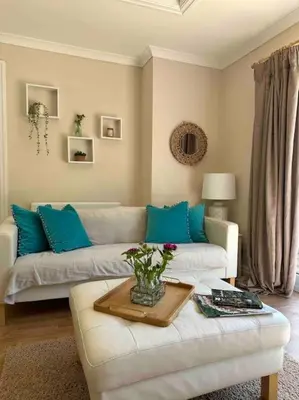 a living room with a white couch and blue pillows at Leafy lodge in Lytham in Brown Moss Side