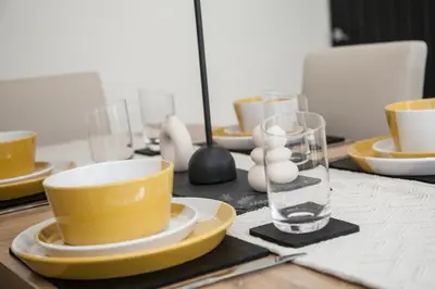 a table with yellow plates and bowls and a glass at 8 Karslake Road in Wallasey