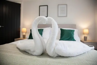 two swans made out of towels on a bed at 8 Karslake Road in Wallasey