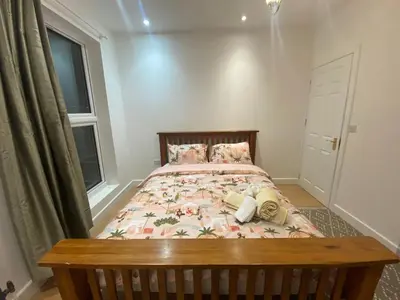 a small bedroom with a bed with a wooden frame at 2 Bedroom New Flat In Blackpool Town Center in Blackpool