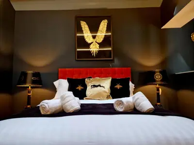 a bedroom with a large bed with pillows and a x at The Hamilton - The Studio luxury holiday let's in Scorton