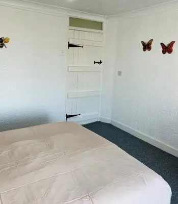 a bedroom with a bed and butterflies on the wall at Willow Cottage - Billinge Wigan, sleeps 4 , parking and garden in Billinge