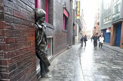 a statue of a boy leaning against a brick wall at *Liverpool City Centre Modern Stylish Apartment in Liverpool