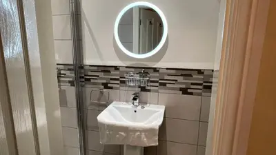 a bathroom with a sink and a mirror at ANFIELD PLACE TO STAY in Liverpool
