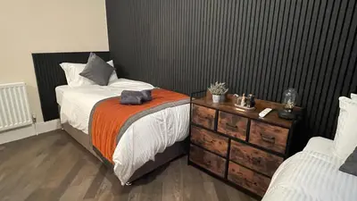 a bedroom with a bed and a dresser with an orange blanket at ANFIELD PLACE TO STAY in Liverpool