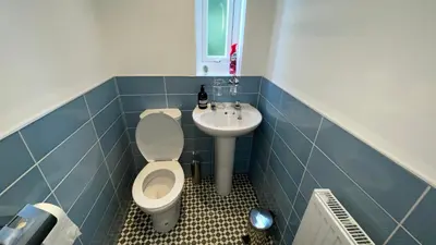 a blue tiled bathroom with a toilet and a sink at ANFIELD PLACE TO STAY in Liverpool