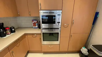 a kitchen with wooden cabinets and a stainless steel oven at ANFIELD PLACE TO STAY in Liverpool