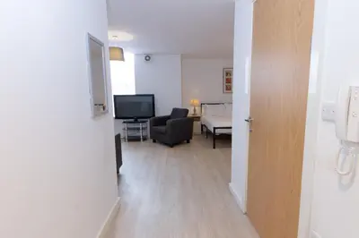 a hallway with a living room with a chair and a television at Cosy Studio Apt in Preston near City Centre in Preston