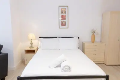 a bedroom with a large white bed with two towels on it at Cosy Studio Apt in Preston near City Centre in Preston