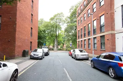 a group of cars parked on a street next to buildings at Cosy Studio Apt in Preston near City Centre in Preston