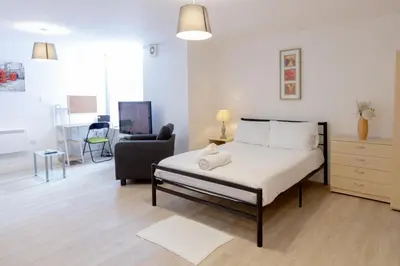 a bedroom with a bed and a chair in a room at Cosy Studio Apt in Preston near City Centre in Preston